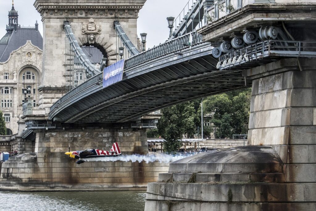 Boedapest, 23 juni - Martin Sonka vliegt onder een brug door tijdens de Red Bull Air Race - ©Red Bull